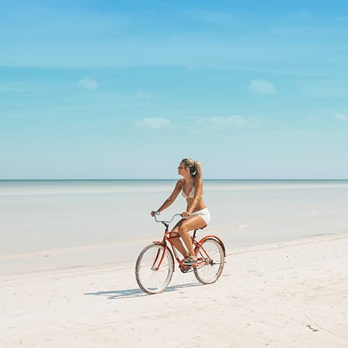 Woman biking on the beach